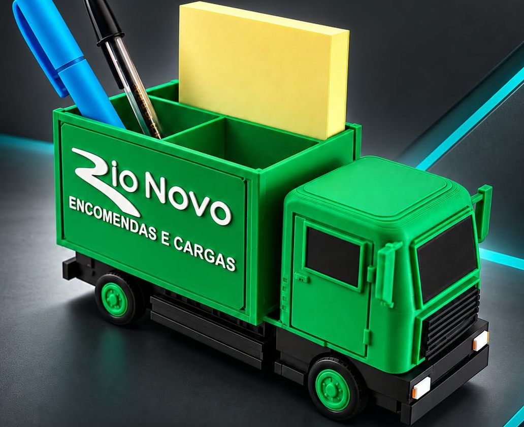 Porta-canetas em formato de caminhão verde com o logo Rio Novo Encomendas e Cargas em relevo, segurando canetas e um bloco de notas