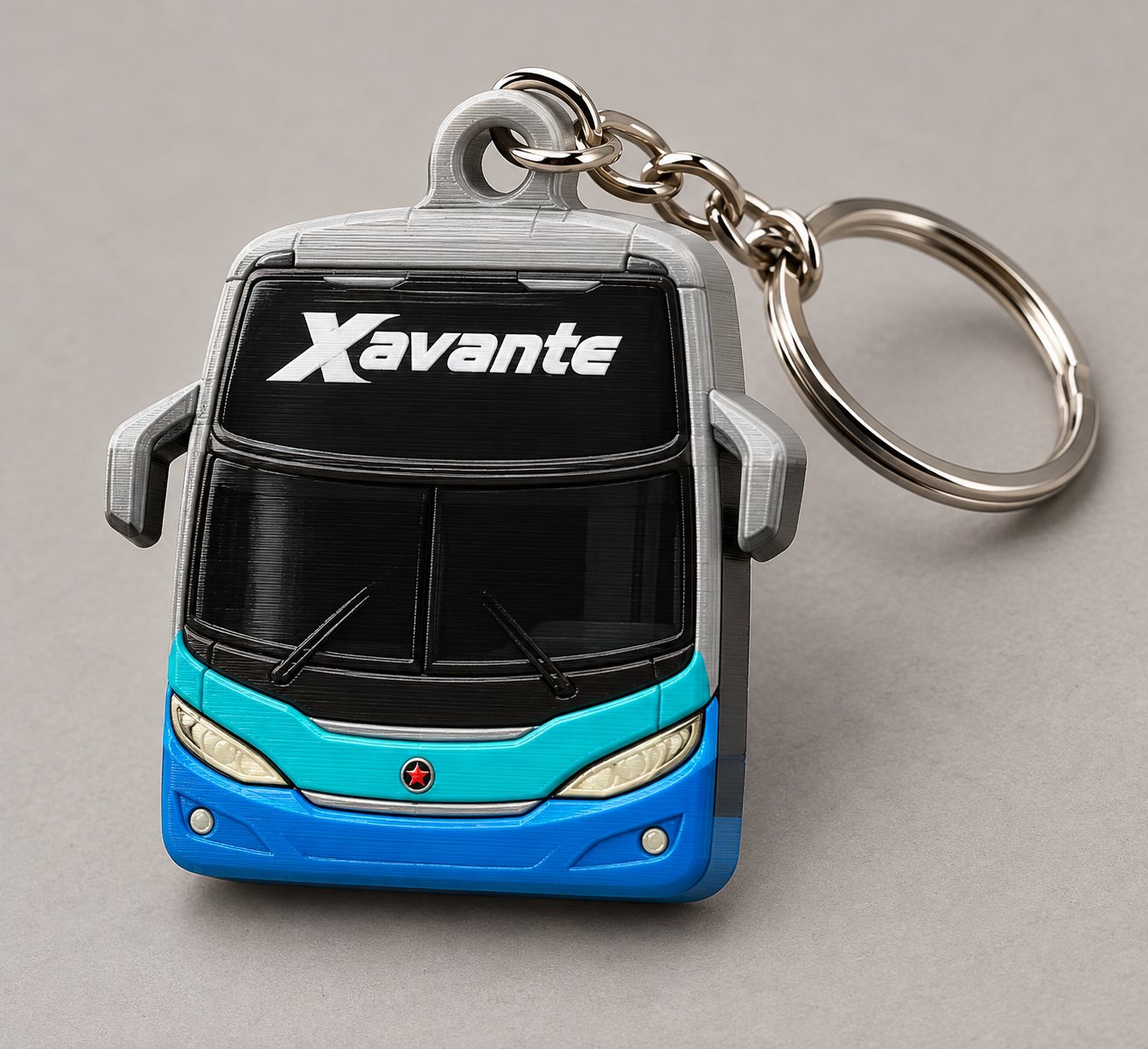 Chaveiro em formato da frente de um ônibus Xavante, impresso em quatro cores, com corrente e argola metálica