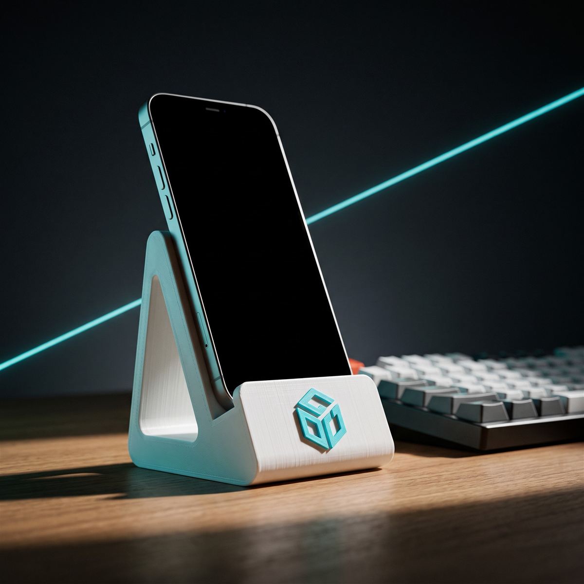 Suporte de celular branco impresso em 3D com logo ciano em relevo, segurando um smartphone sobre a mesa